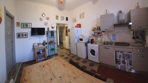 A compact kitchen with a ceiling fan, a washing machine, a microwave, and a sink. - A46 Foresteria Lombarda (Monza)