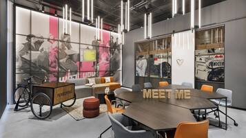 A modern meeting room with a large table, comfortable seating, and a bicycle cart.