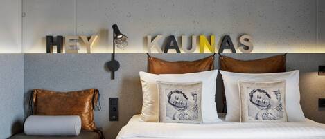 Una habitación de hotel moderna con cama, sofá e iluminación empotrada.