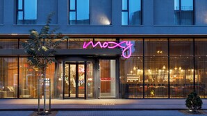 A modern building with a glass facade and a neon sign reading "mozy". - Moxy Kaunas Center (Kaunas)