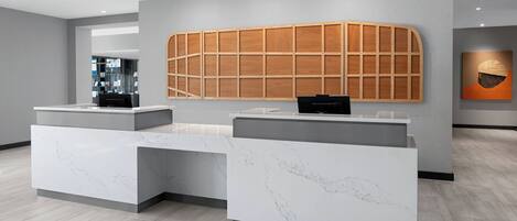 A reception area with marble counters and a wooden panel wall.