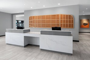A reception area with marble counters and a wooden panel wall. - AC Hotel by Marriott Santa Rosa Sonoma Wine Country (Santa Rosa)