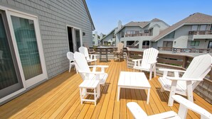 A deck with white chairs and a table, overlooking a residential area. - Oceanside, Hot Tub, Community Amenities, Close to beach, 665, Shore Beats Work (Corolla)