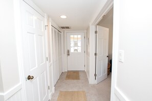 A hallway with white doors, a doormat, and a ceiling light. - Semi-Oceanfront, Private Pool, Ocean Views, Close to beach, BU76, Trading Winds (Corolla)