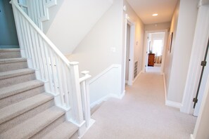 A staircase with white railings leading to a landing.