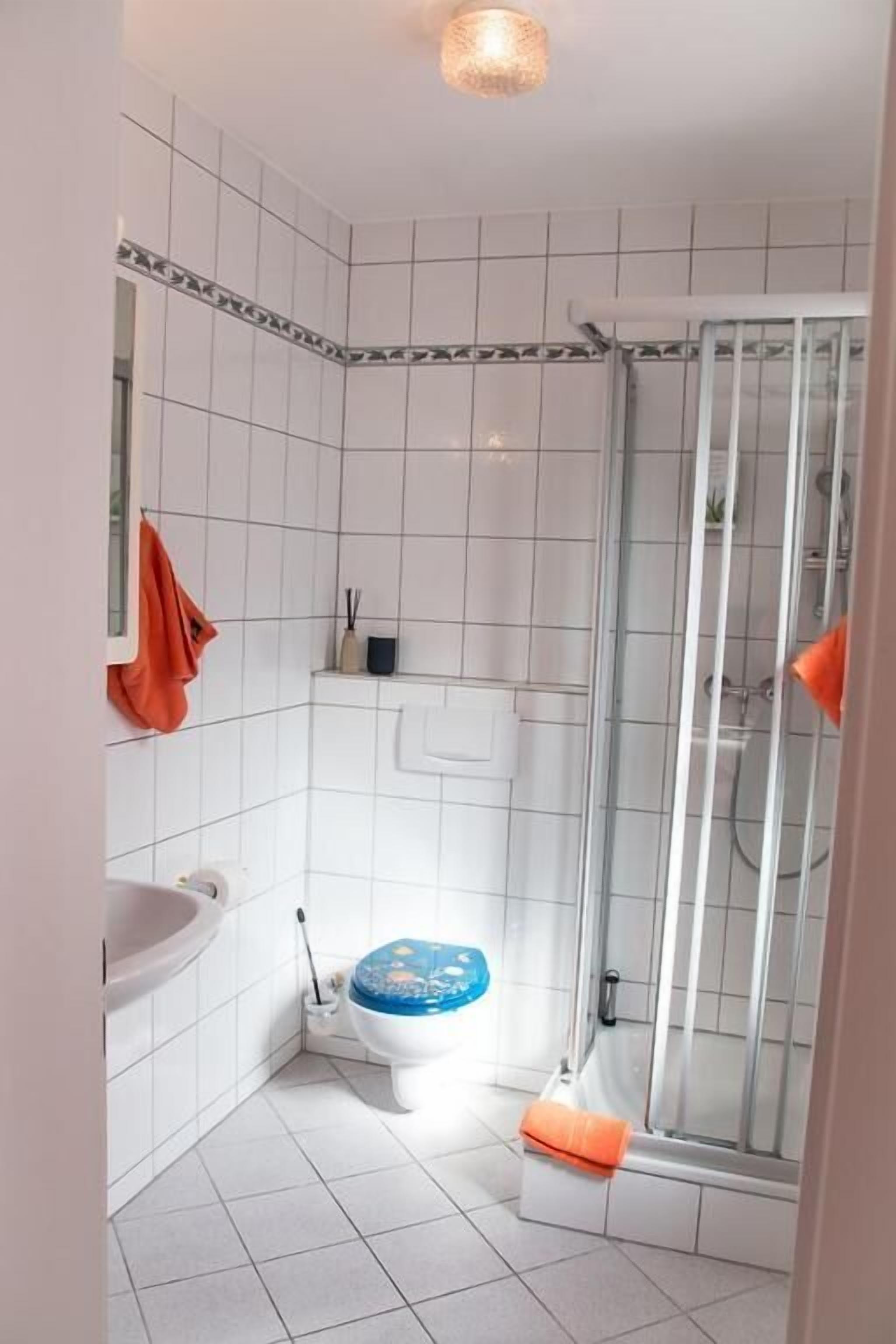 Un baño pequeño con inodoro, lavamanos y ducha.