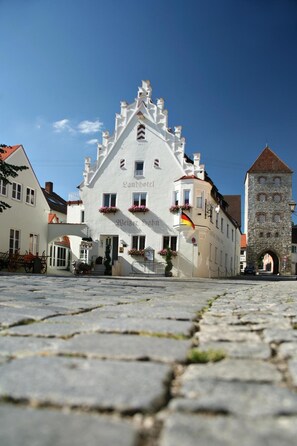 Um edifício histórico com um telhado íngreme e uma torre.