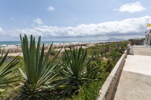 A coastal view with a beach, a clear sky, and a distant mountain. - ANNA - Fantastic house right in front the beach in Denia (Dénia)