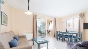 Un soggiorno moderno con un divano, un tavolino da caffè e un'area pranzo con tavolo e sedie.