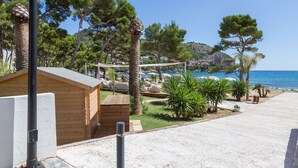 A beachside property with a wooden cabin, a sandy patio, and a view of the sea. - ORO DEL MAR IV Apartamento O2 - Apartment near the beach and with shared pool Free WiFi (Capdepera)