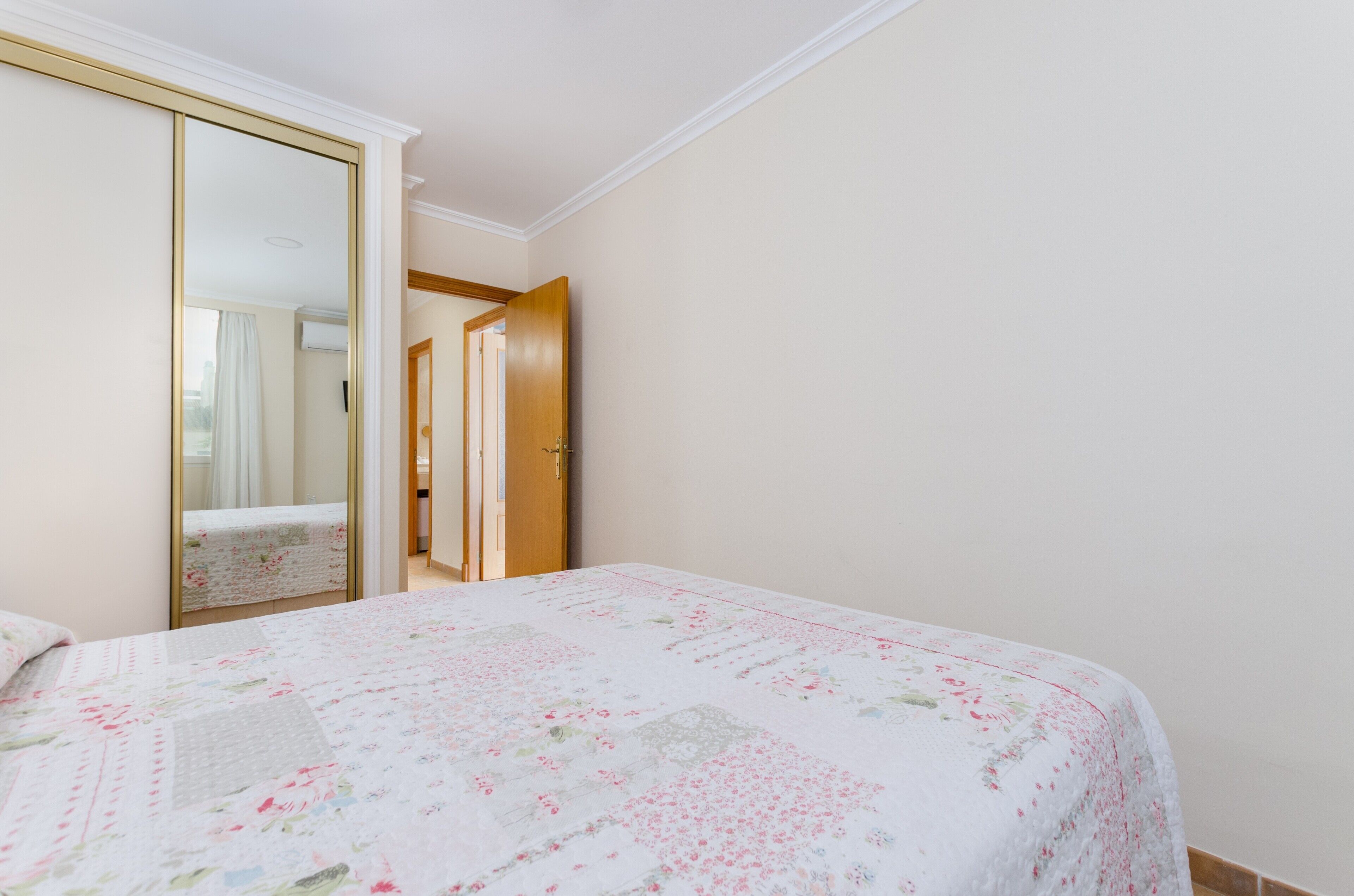 Un dormitorio con una cama, un armario y una puerta que da a otra habitación.
