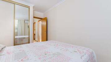 Un dormitorio con una cama, un armario y una puerta que da a otra habitación.