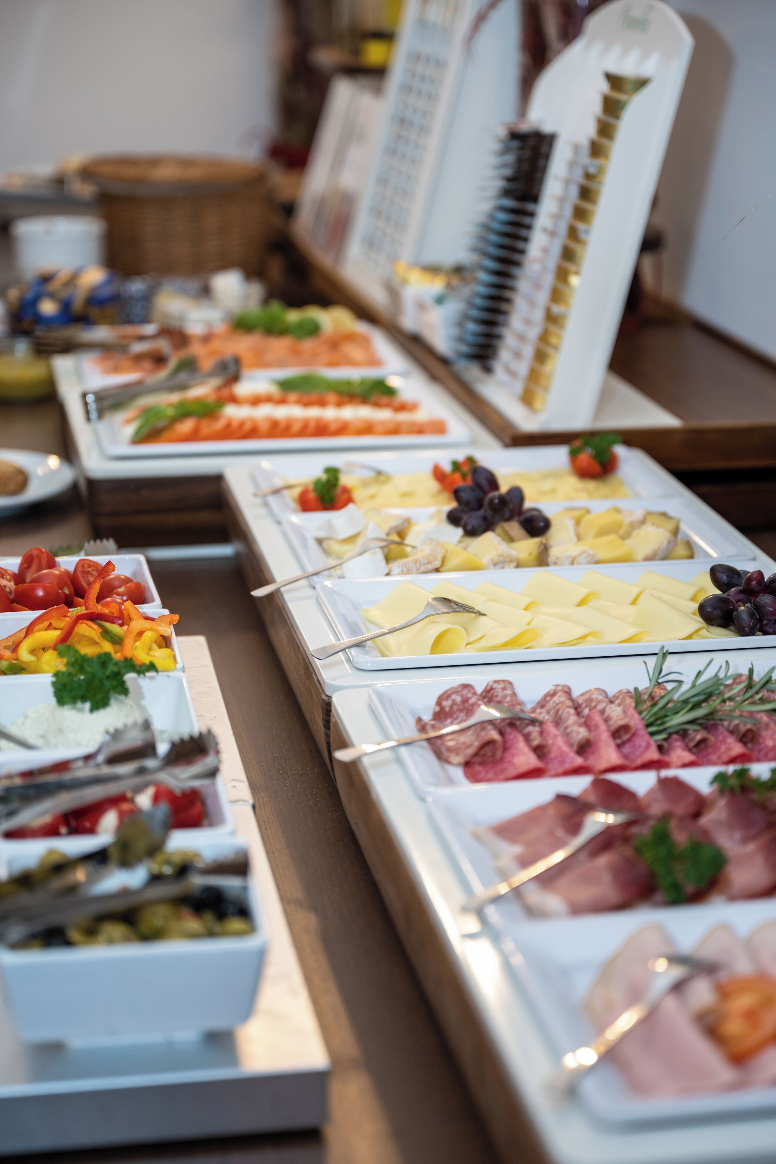 Ein reichhaltiges Buffet mit verschiedenen Speisen, darunter Fleisch, Käse und Gemüse.