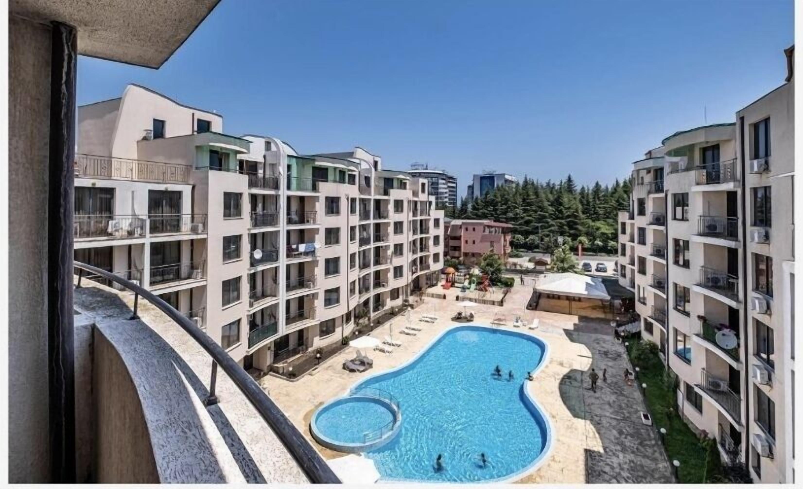 A residential building with a swimming pool and outdoor seating area.