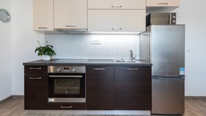 Una cocina moderna con horno empotrado, refrigerador de acero inoxidable y microondas.
