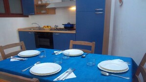 A small kitchen with a blue table set for four.