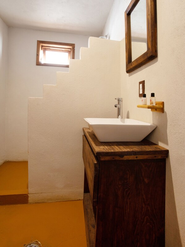 A bathroom with a white sink, wooden vanity, and a small window above the mirror. - Hotel Vista del Bosque, Villa del Carbón (Villa del Carbón)
