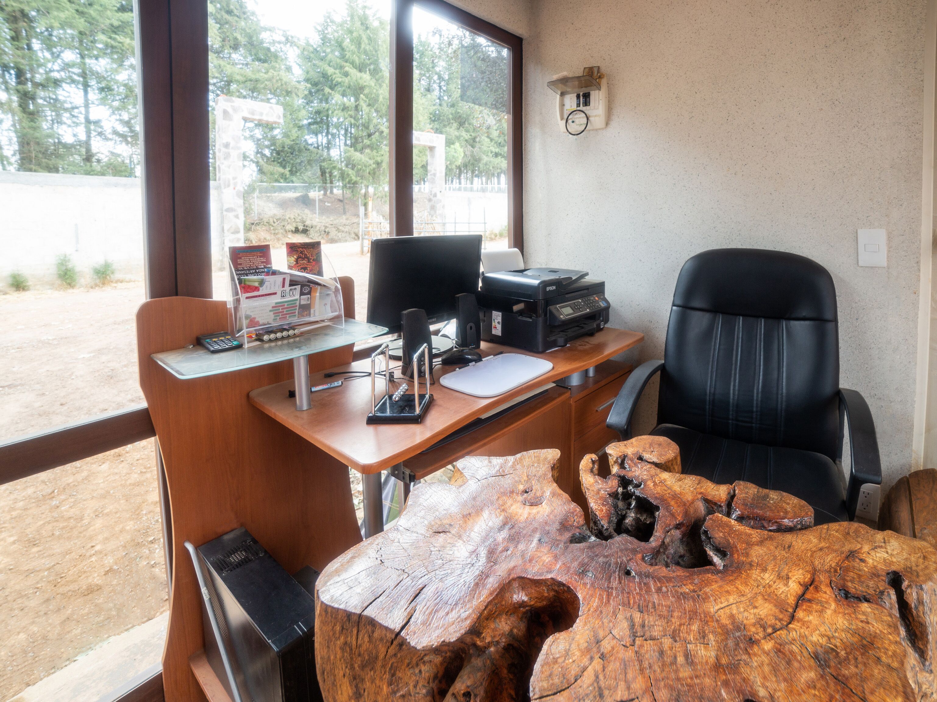 A wooden desk with a computer, printer, and a wooden coffee table.