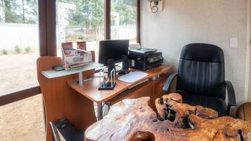 A wooden desk with a computer, printer, and a wooden coffee table.