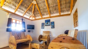 Una habitación rústica con muebles de madera, un televisor y cuadros en la pared.