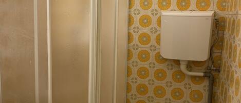 A bathroom with a shower, toilet, and sink.