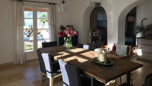 Un coin repas avec une table en bois, des chaises et un vase de fleurs.