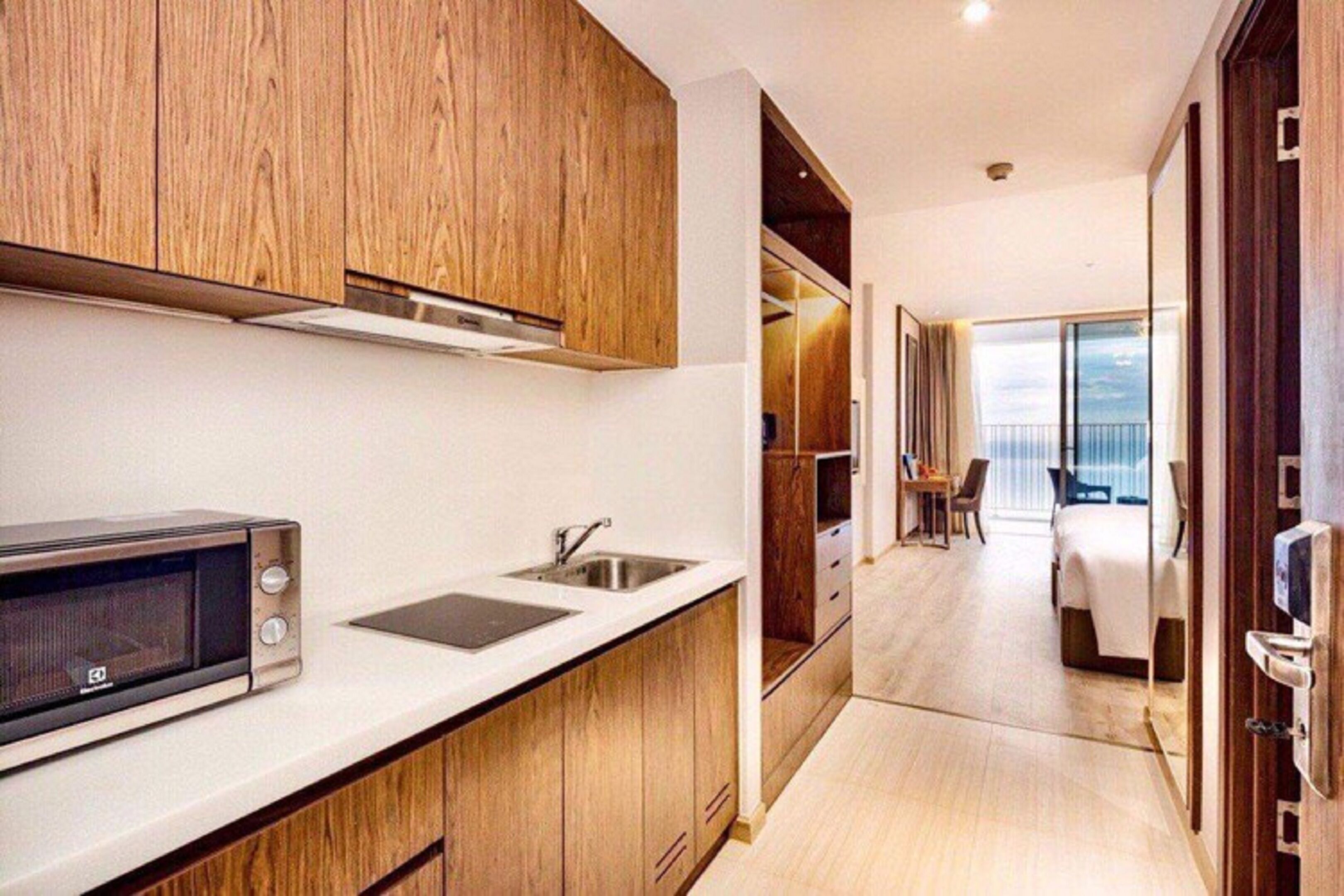 Una cocina moderna con armarios de madera, un microondas y un lavabo.