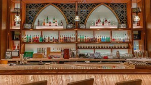 A bar with multiple shelves of liquor bottles, a counter with glasses, and wooden decor. - Homie Panorama Nha Trang (Nha Trang)