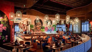 A restaurant with a curved seating area, a counter with a variety of dishes, and hanging birdcage lights. - Homie Panorama Nha Trang (Nha Trang)