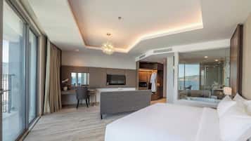 Una habitación de hotel moderna con una cama grande, un escritorio con silla, una televisión y un vestidor.