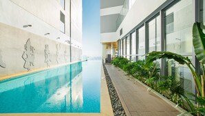 A modern indoor swimming pool with clear water, surrounded by a tiled deck and potted plants. - Homie Panorama Nha Trang (Nha Trang)