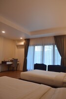 Habitación de hotel con dos camas, un escritorio y una silla.