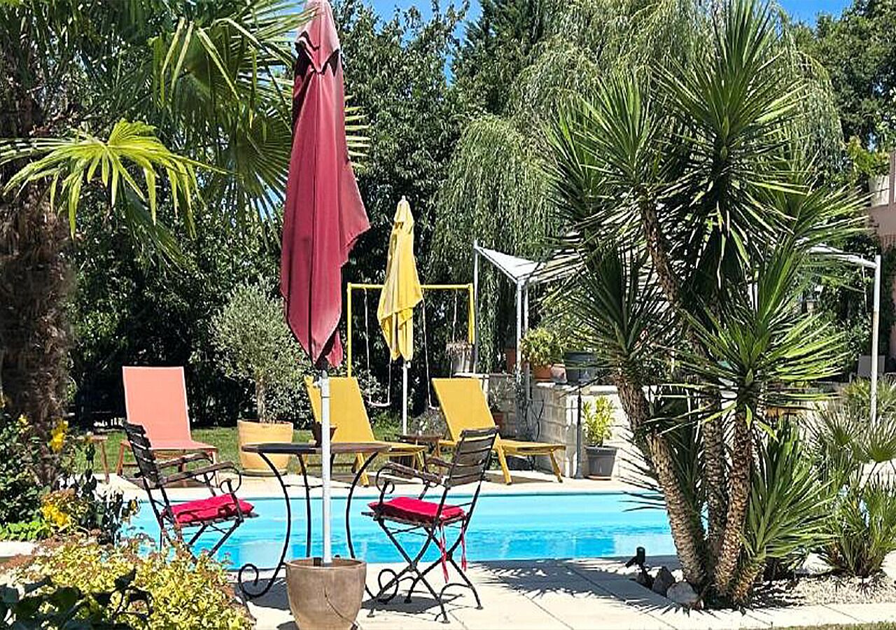 A pool area with lounge chairs and umbrellas.