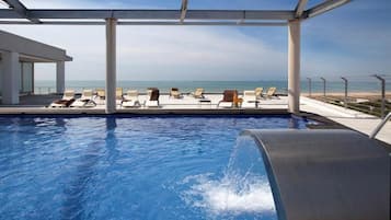 Una piscina al aire libre de temporada, sombrillas