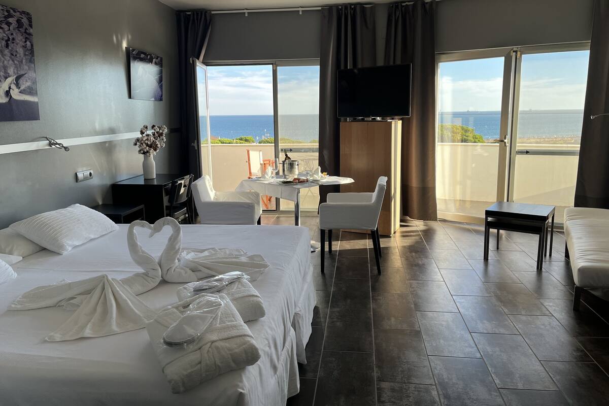 Junior suite, uitzicht op zee | Een kluis op de kamer, een laptopwerkplek, verduisterende gordijnen