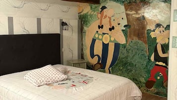 A bedroom with a large bed, wooden beams, a mural, and a nightstand.