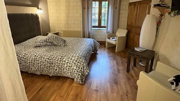 Ein gemütliches Schlafzimmer mit einem großen Bett, einer kleinen Couch und einem Fenster mit Vorhängen.
