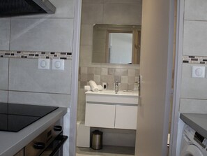 Une salle de bain moderne avec un lavabo, un miroir et un porte-serviettes.