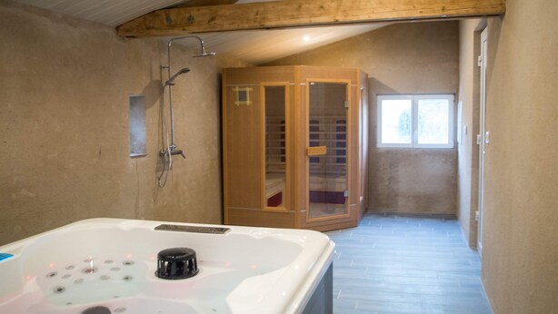 A bathroom with a wooden sauna, a bathtub, and a shower.