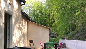 An outdoor patio with wicker furniture, a table, and chairs.
