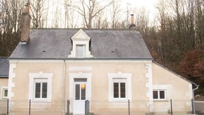 A two-story building with a pitched roof, a small dormer window, and a front door.