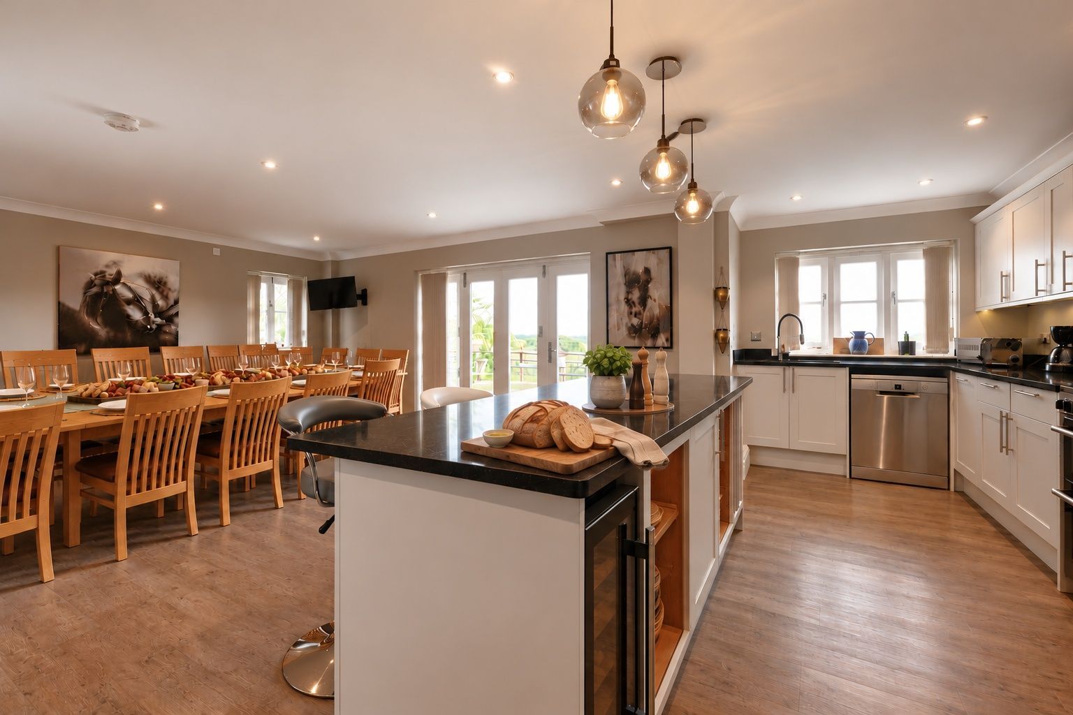 A modern kitchen with a central island, wooden dining table, and chairs.