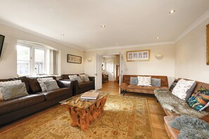 A spacious living room with two sofas, a coffee table, and a patterned rug.