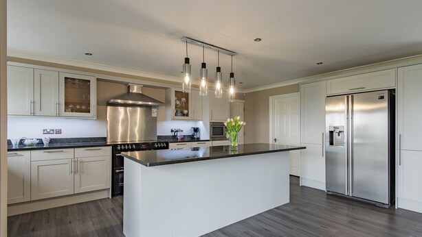 A modern kitchen with white cabinetry, a stainless steel range hood, a double-door refrigerator, and pendant lighting. - The Homestead by Bloom Stays - sleeps 17 (Canterbury)