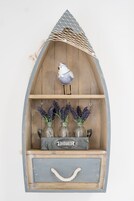 A wooden boat-shaped shelf with a bird figurine, lavender in jars, and a 'WELCOME' sign.