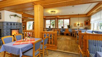 A cozy restaurant with wooden interiors, a fireplace, and blue upholstered seating.