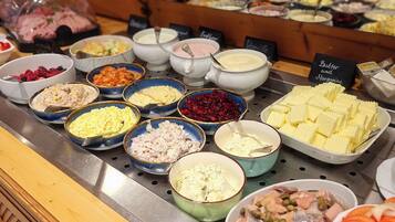 A buffet with various food items and condiments.