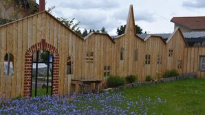 A wooden building with a brick archway and multiple windows. - Spacious and bright family accommodation in Chazelles-sur-Lyon (Chazelles-sur-Lyon)