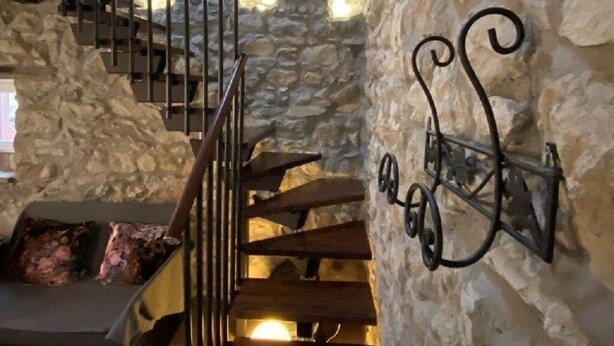 A stone staircase with a metal railing leading to a landing. - Ancient turret of 1800 surrounded by nature - whole structure (Barbarolo)