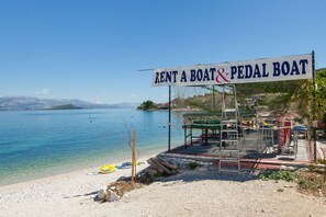 A beachside rental area with a sign for boat and pedal boat rentals.